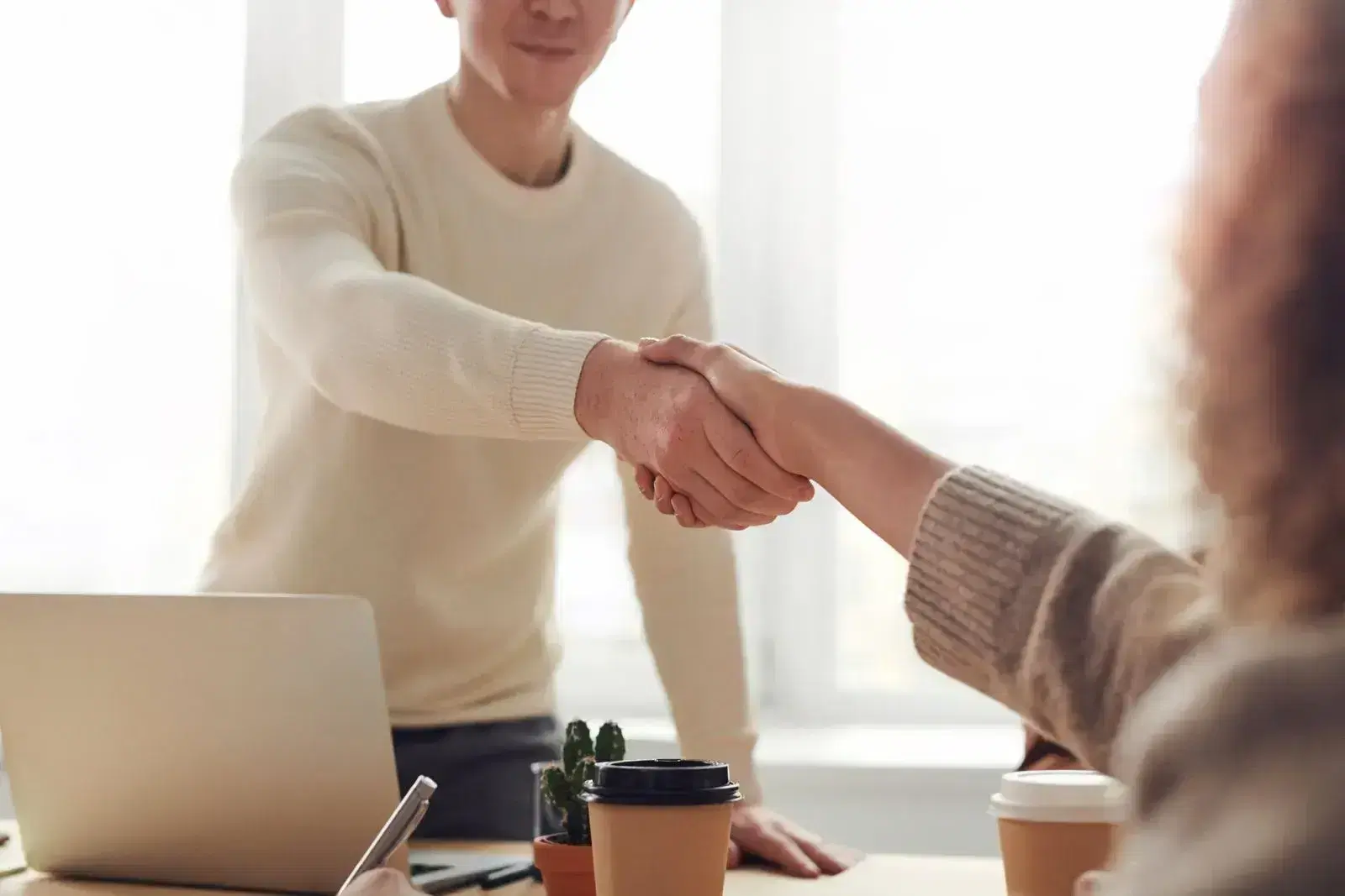 Two people holding hands in agreement